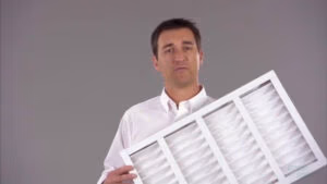 Comfort Experts Air Tech holding up an AC Filter explaining different components