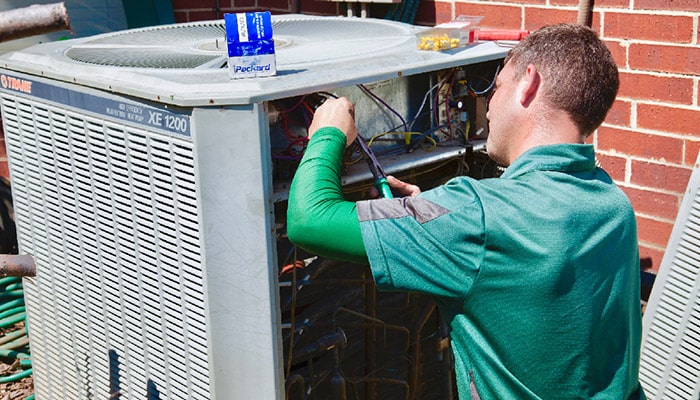 AC technician checking air conditioner