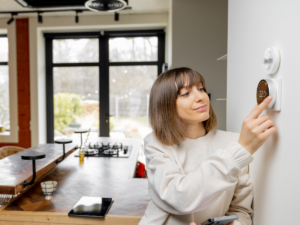 woman adjusting her nest thermostat 