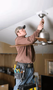 electrician performing ceiling fan installation