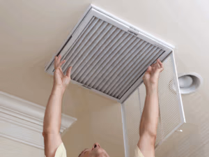 Homeowners changing out dirty air filter
