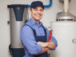 smiling plumber posing next to long last water heater