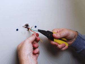 HVAC tech finding RC and RH wires for new thermostat installation 