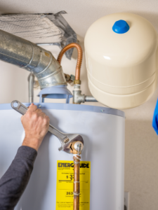 Plumber making finishing touches of water heater replacement 