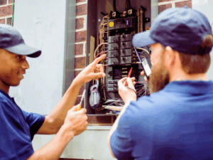 Electricians inspecting electrical panel 