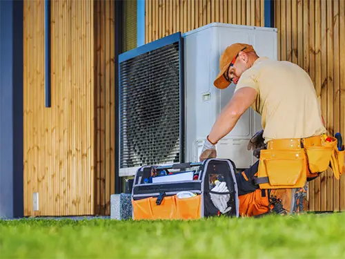 HVAC technician servicing an outdoor air conditioning unit at a residential home in Texas