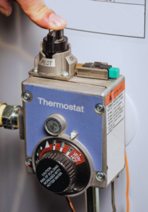 Homeowner relighting pilot light on hot water heater